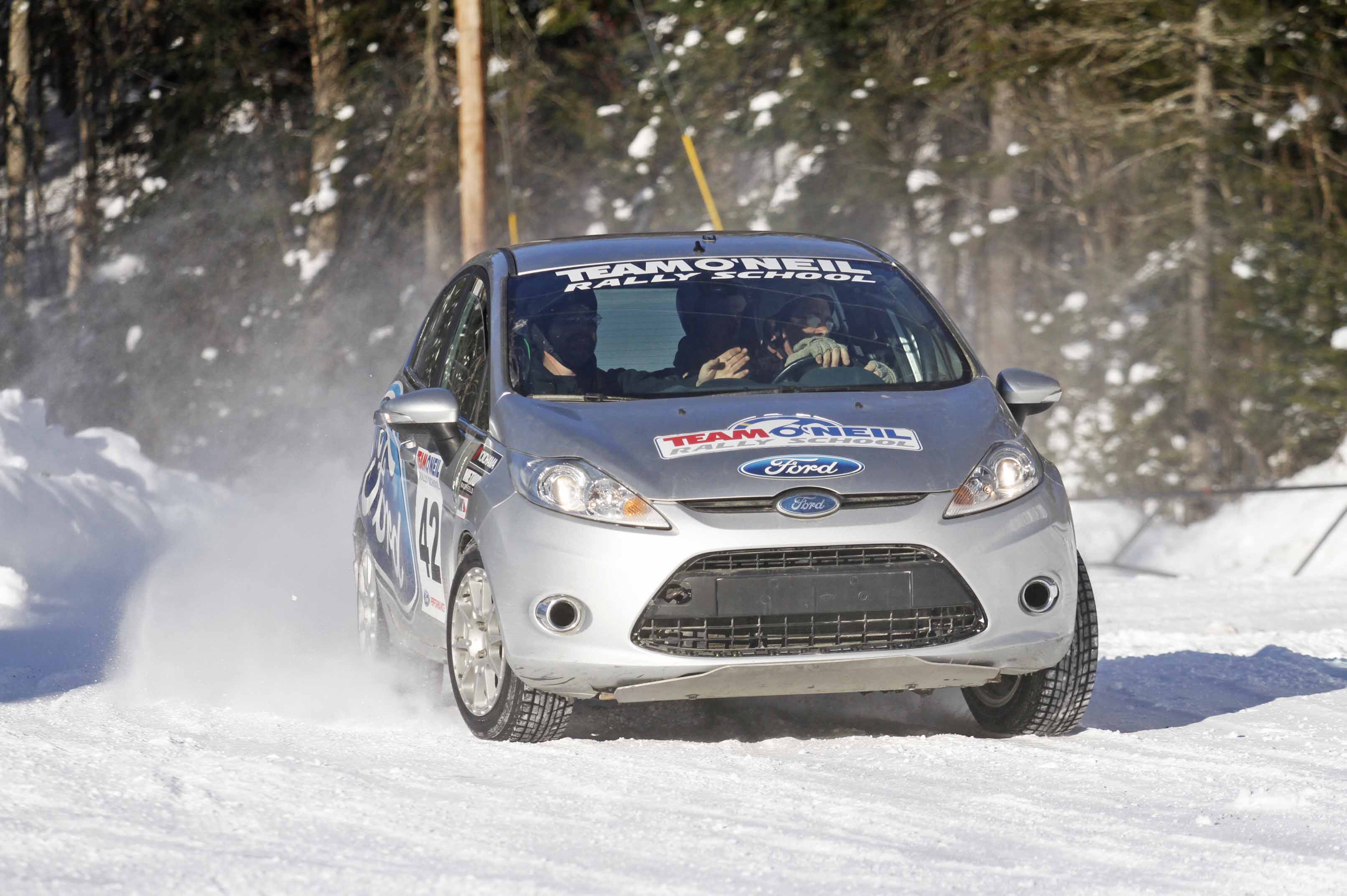 rally car turning on snow covered course